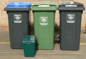 A blue lidded wheeled bin, green wheeled bin and grey wheeled bin and a green kerbside caddy