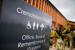 Sign pointing visitors to the toilets, office, book or remembrance and gardens