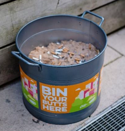 Bucket bin full of sand and discarded cigarette butts